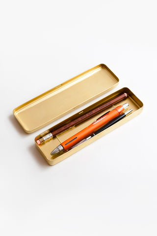 Open gold brass pen case holding pens with orange and black bodies