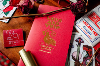 Red Traveler's notebook refill booklet with gold Love and Trip cover, angled view