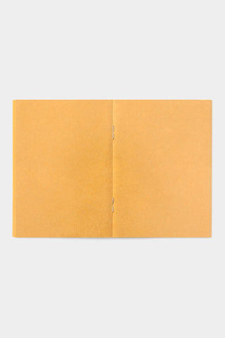 Yellow kraft passport-size notebook opened flat, two-panel cover