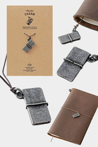 Pewter mini book charm on leather cord, shown with brown notebook cover