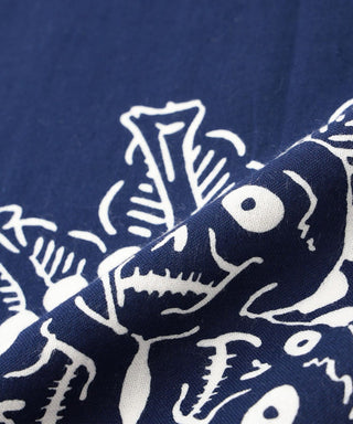 Dark blue tenugui towel close-up of white creature face and leaf-like shapes