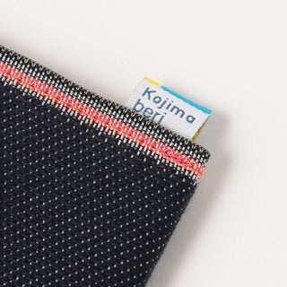 Kojima denim label on dark blue coin purse edge with red stitched trim