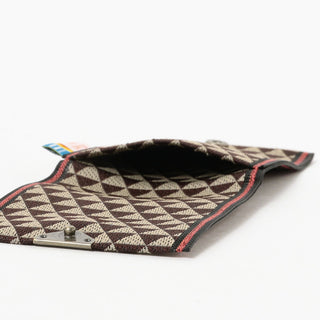 Coin purse interior view with cream-and-brown triangular pattern lining and metal clasp