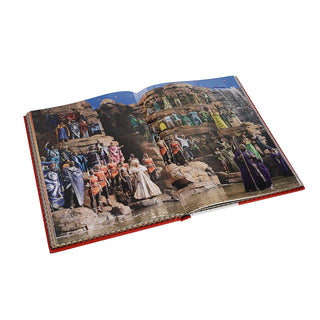 Open art book with collage-style costume images across a wide photo spread