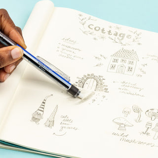 Hand using a blue and black mechanical pencil to draw on a sketchbook