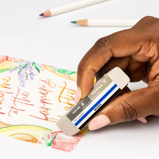 Hand holding a beige Tombow MONO sand and rubber eraser
