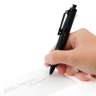 AirPress ballpoint pen, black barrel, writing on white paper with hand
