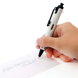 White AirPress ballpoint pen with black clip, held above white paper