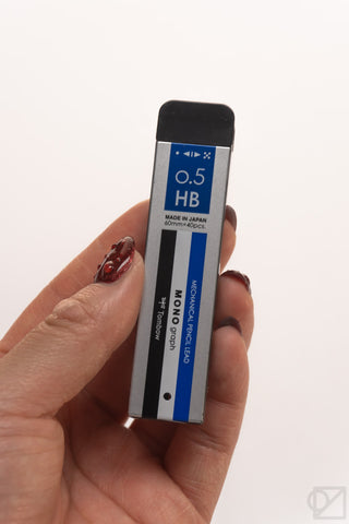 Tombow MONO 0.5 mm HB pencil lead refills package held in hands