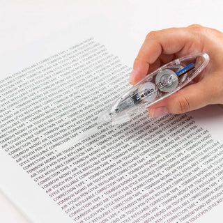 Transparent MONO Air Touch correction tape applicator held over printed text