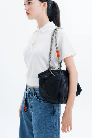 Rope loop strap in dark gray/black weave with orange accent, worn over shoulder