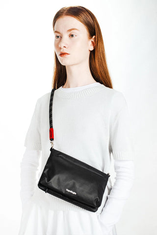 Black and white rope strap with red accent tab and metal clips, worn across chest