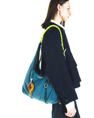 Neon lime braided O-rope strap on a blue crossbody bag, worn on shoulder