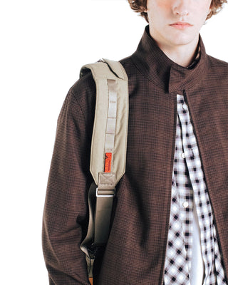Topologie bomber strap with beige pouch and adjustable webbing strap over brown jacket