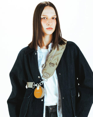 Olive crossbody bomber strap with metal buckles and small round orange pouch