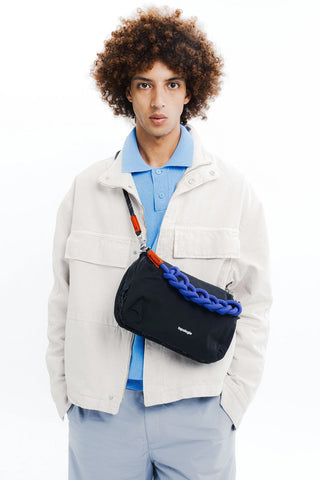 Black sling bag with braided strap detail, worn across the chest