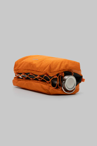 Burnt orange ripstop bottle sacoche with bottle and top pouch on its side