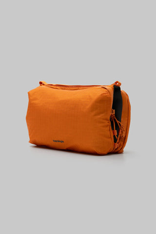 Burnt orange ripstop bottle sacoche with rounded shape and side straps