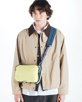Canary yellow bottle sacoche worn crossbody with adjustable navy strap