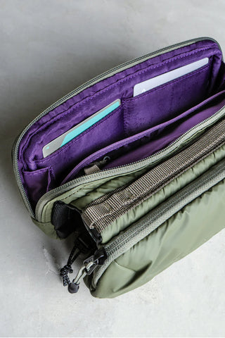 Purple Topologie bottle sacoche interior with zipper pockets and teal-lined sleeve