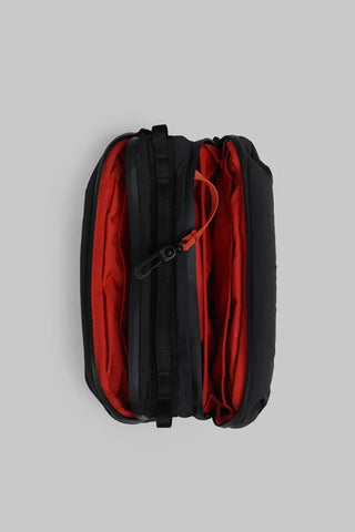 Topologie medium bottle sacoche bag, black exterior with red lined interior and zipper.
