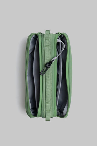 Topologie medium bottle sling bag in ivy green, close-up of zipper and webbing loops
