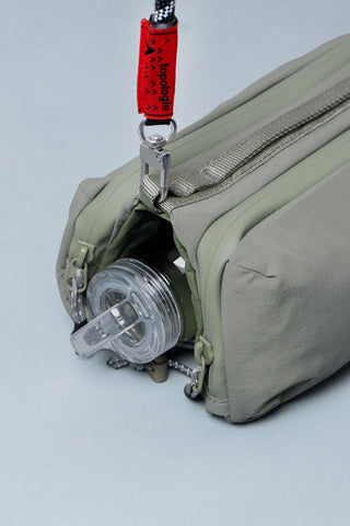Medium bottle sling bag with bottle secured in side compartment, zipper close