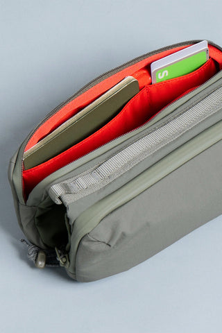 Medium bottle sling bag side view, red-lined interior organizer and inner pocket