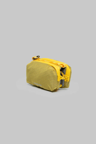Mustard yellow mini bottle pouch with textured ripstop fabric and drawstring closure.