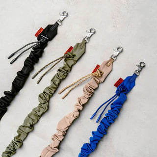Set of bungee straps in black, olive, beige, and blue with metal clips