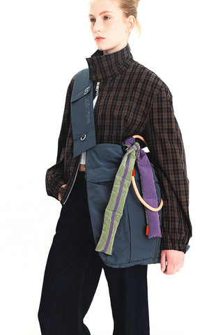 Topologie sling bag with navy body and colorful strap trim, logo patch