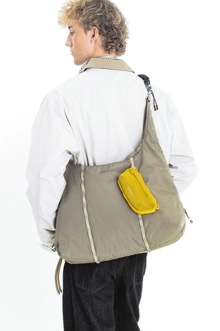 Mini crossbody bag with olive panel, yellow front pocket, and zipper closure