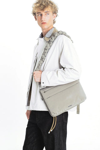 Moss green cloud strap on shoulder with metal clips and woven adjustable strap