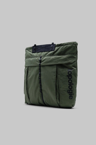 Deep green nylon helmet bag with pleated front panel and dark vertical webbing