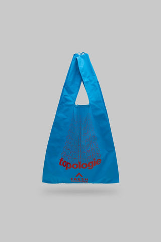 Atomic blue Topologie Konbini bag with red logo and wide triangle shape