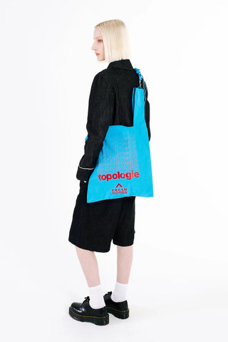 Topologie Konbini bag worn by model, atomic blue with red logo