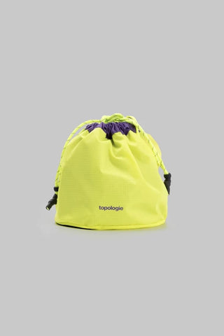 Reversible bucket bag in neon yellow with drawstring, cords, and topologie logo.