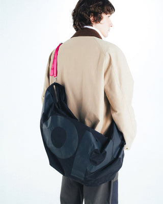 Black hobo bag worn over shoulder with circular pattern on slouchy body
