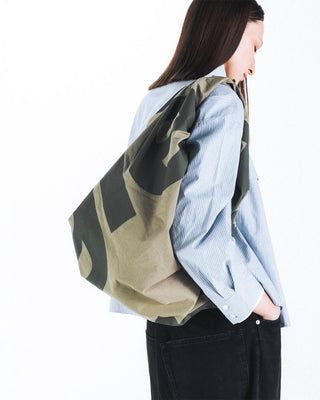 Topologie Robo bag side view on model, moss green and beige circle print