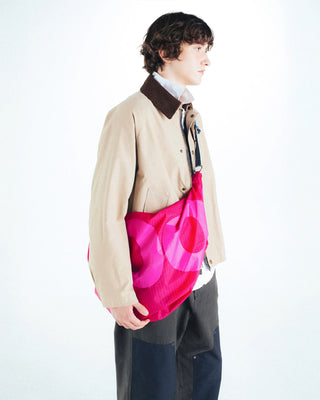 Topologie Robo bag in bright pink translucent ripstop, worn on shoulder with open top