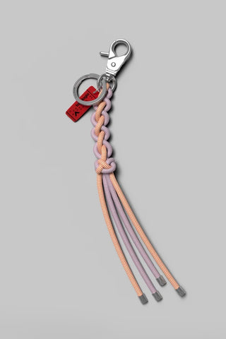 Topologie Sinnet keychain with braided cord and metal clip, red Cheshire Cat tag