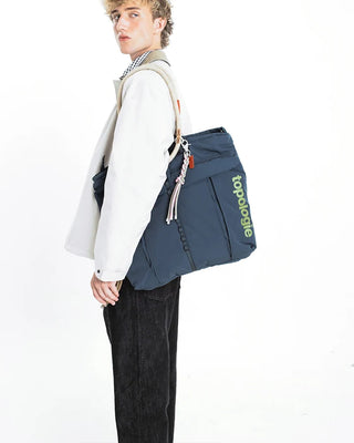 Topologie Sinnet keychain with braided tassels and metal clip on blue bag strap
