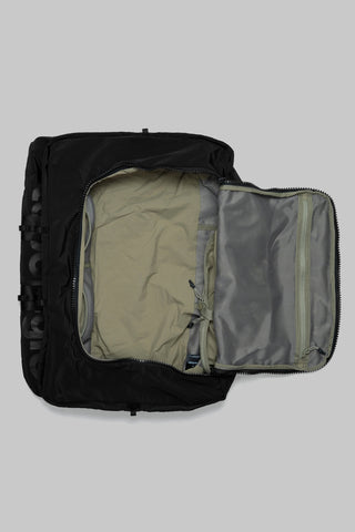 Black duffle bag open showing light interior lining and zippered compartments