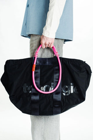 Black duffle bag with pink handle loop and front logo embossing