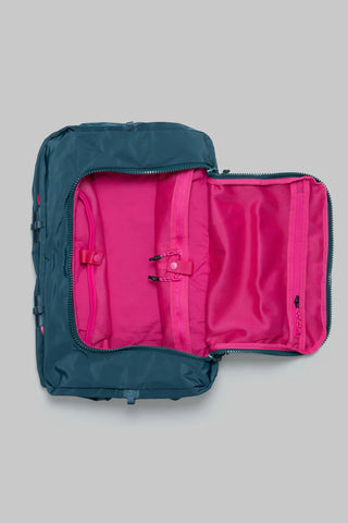 Teal duffle bag open to reveal bright pink interior with zip pockets