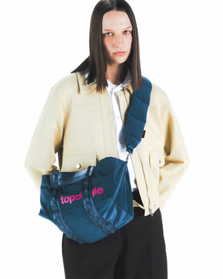 Small duffel bag with adjustable strap worn crossbody, deep teal tech sateen, front logo