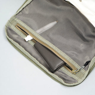 Interior pocket of moss green duffle bag with mesh panel and zipper