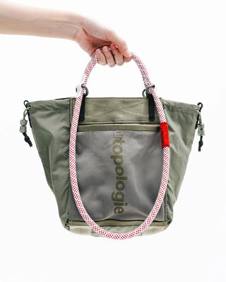Small tote bag in olive green with pink-and-white rope handles and front zip pocket