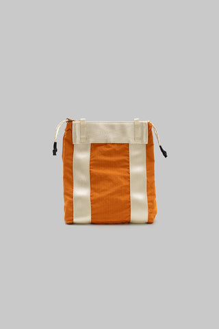 Small tote bag in burn orange with white vertical stripes and drawstring top.