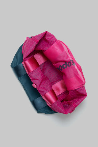 Small tote bag with pink lining and teal side panels, angled view